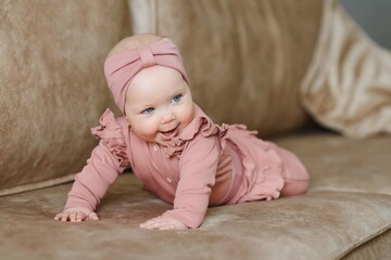 Portrait of a cute 6-month-old baby, a newborn girl lying in a bed.