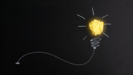 Great idea concept with crumpled yellow paper light bulb isolated on dark background.Creative idea....