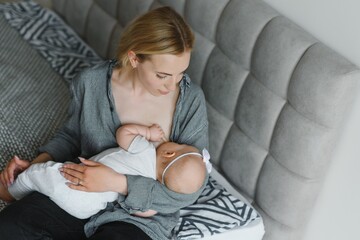 Lactation concept. Young mother breastfeeding her newborn baby at home, close up