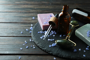 Skin care concept with face roller on rustic wooden table
