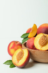 Fototapeta na wymiar Wooden bowl with peach fruits on white table