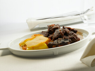 Ragout con patatas, en mesa con mantel. Ragout with potatoes, on a table with a tablecloth.