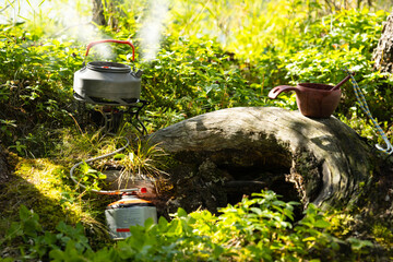 Camping kettle boiled on a gas burner outdoor