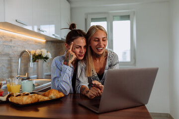 Women lgbtq couple in the kitchen having video call