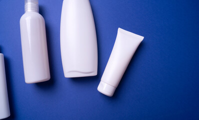 various plastic packaging for shampoo and cream on a blue background