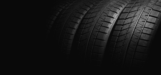 new winter car tires on black background. copy space