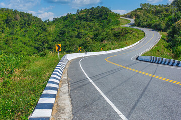 Curved asphalt road with sign curves in the mountains. Nan province, Thailand