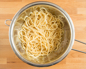 Boiled spaghetti in a colander without spices. Draining