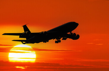 Fototapeta na wymiar Silhouette of airplane flying in sunset