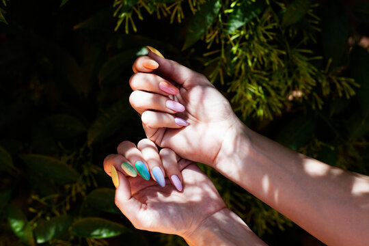 Close up shot of a young woman's hands showing her rainbow colored manicure. LGTBIQ+ theme