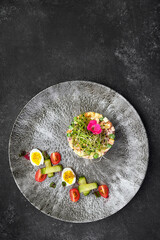 Olivier salad on a gray beautiful plate, on a dark background. restaurant serving