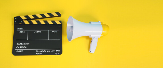 Clapperboard or movie clapper board in yellow and black color and Megaphone isolated on yellow...
