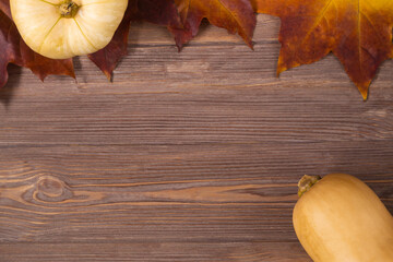 Halloween fall background with maple leaves and pumpkin on the wooden table with copy space