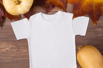 Halloween fall T-shirt mockup on the background with maple leaves and pumpkin on the wooden table, template, mock up