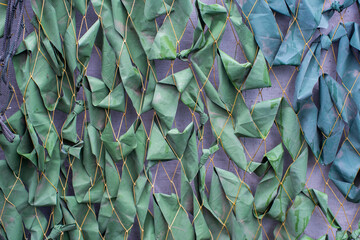 Naklejka na ściany i meble Military background. The surface of a camouflage army tent, green mesh. Abstract texture.