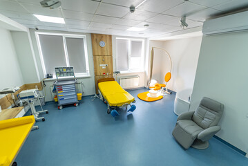 Bed for mother and newborn child cradle in modern hospital. Up-to-date interior in clinic. Light colors in clinic room. Closeup