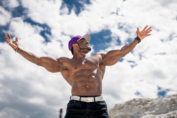 Freedom. American cheerful topless man stretching his arms at the sandy beach. Attractive handsome...