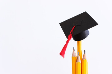 Image of education concept. Traditional graduation hat over pencils