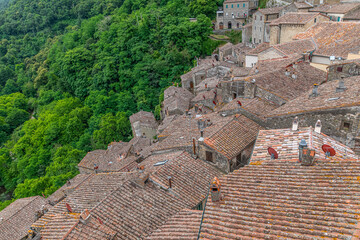 picturesque view of Sorano with old staircase, alley, underpass and plants in the Tuscan medieval...