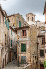 Fototapeta na wymiar picturesque view of Sorano with old staircase, alley, underpass and plants in the Tuscan medieval village