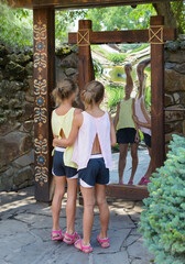 Twins caucasian girls in front of distorting mirror