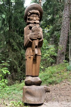 Ein Fischer mit einem Fisch - Eine der vielen Holzskulpturen im Wald des Hexenberges bei Juodkrante auf der Kurischen Nehrung in Litauen