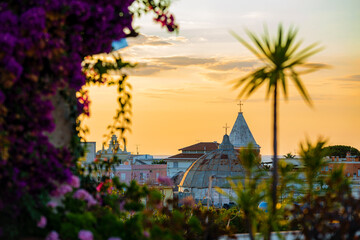 Sunset on Ischia island Italy with church domes and palm tree