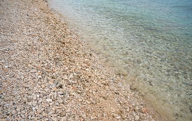 The bottom of the sea with small pebbles along with water.