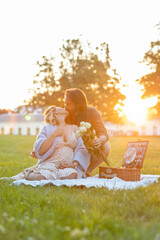 Beautiful young couple kissing at a picnic at sunset
