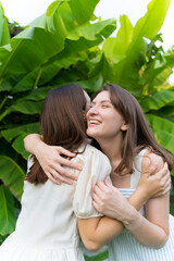 Two young friends met after quarantine. Hugs. Friendship and family. Happy sisters smile and hug after separation