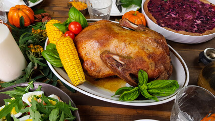 duck for a traditional family dinner in honor of the Thanksgiving holiday. beautifully set table with pumpkins, and autumn seasonal dishes.
