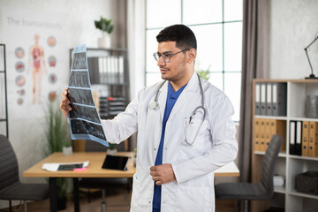 Medical diagnosis concept. Portrait of male Arab doctor oncologist physician examining lungs x-ray...