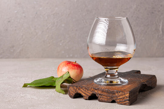 calvados in a wine glass on a wooden board space for text