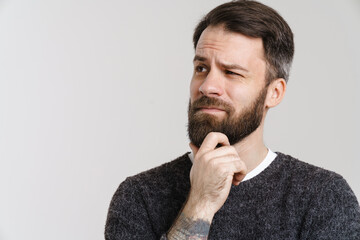 White puzzled man with beard posing and looking aside