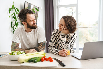 Smiling young white couple sitting at the table