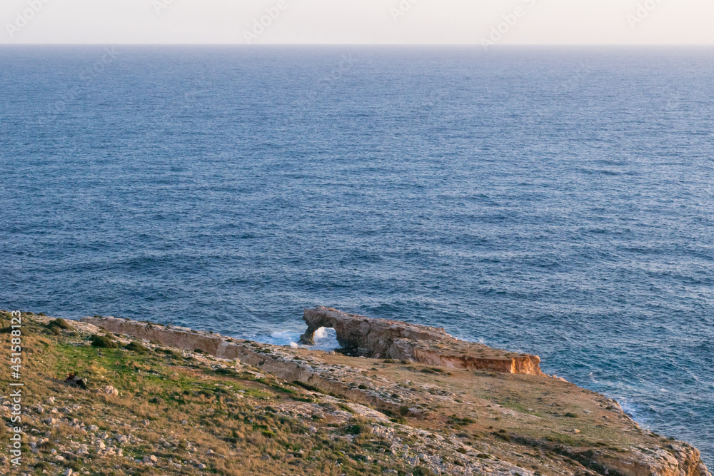 Poster natural sea arch formed by sea erosion at the tip of a headland called ras il-hamrija, malta