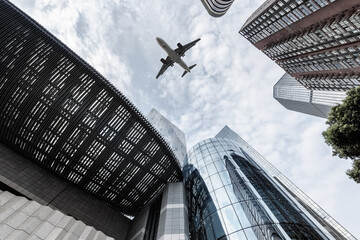 upward view of airplane and modern building