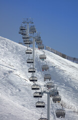 ski lift at a ski resort high in the mountains. chairlift for skiers and snowboarders. high-quality poster - the opening of the ski season