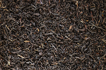 A scattering of dried black tea leaves close-up.