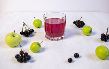 Homemade compote of apple fruit and chokeberry in glass on white background
