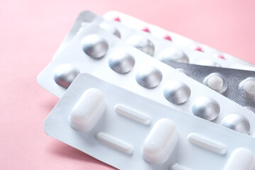 Close up of pills of blister pack on pink background 