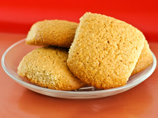 Several homemade oatmeal cookies on a glass saucer