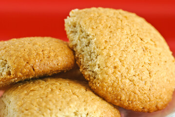 Homemade oatmeal cookies on red background, close-up