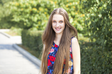 Naklejka premium Portrait of a young beautiful brunette girl in summer park