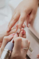 Fotobehang Manicure, handen close-up. Professionele manicure in schoonheidssalon. Hygiëne en verzorging van de handen. Schoonheidsindustrie concept. © Aldana