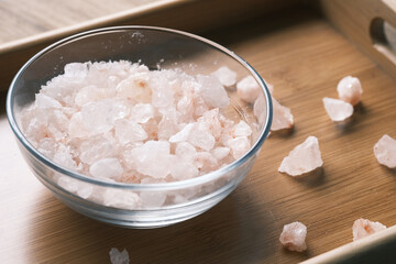 close up of pink rock salt in a bowl on table 