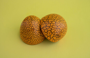 The concept of Easter. Brown toy open spotted egg on a yellow background