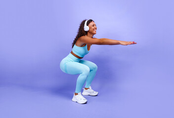 African American woman doing simple sports exercises stretching the muscles of her body, being in a good mood,