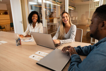 diverse business workgroup in informal conversation in meeting room.