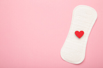 Menstrual pads on pink background. Menstruation cycle. Hygiene and protection. A heart on a menstrual pad.
